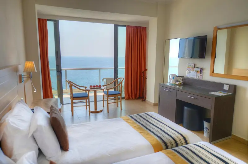 Chambre lumineuse avec vue sur la mer et un coin salon.