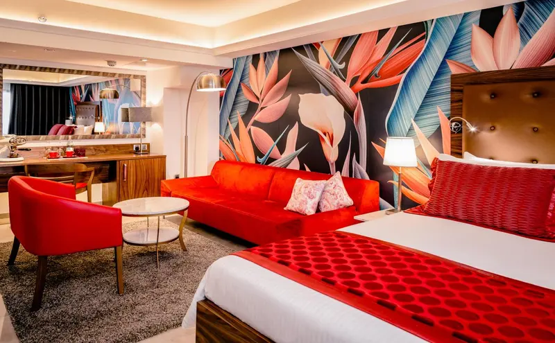 Un salon et une chambre à coucher aux couleurs vives et au décor tropical.