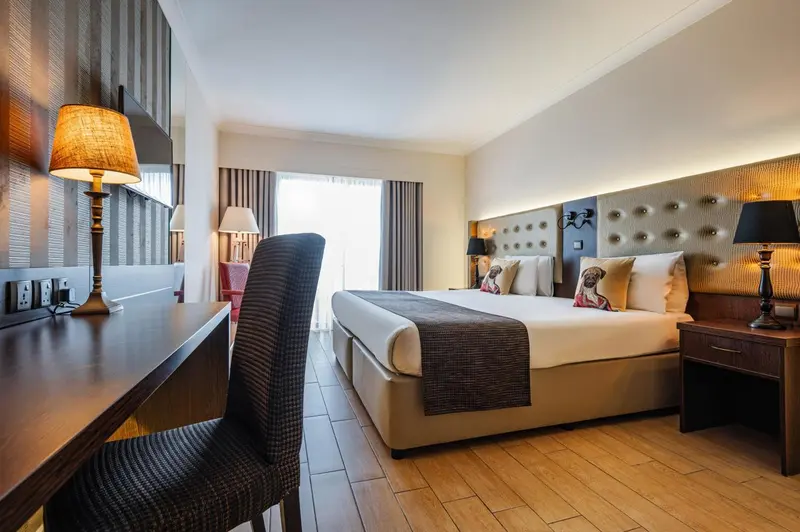 Une chambre d'hôtel moderne avec un grand lit et un bureau.
