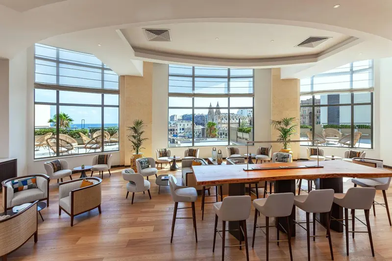 Espace de détente lumineux avec mobilier confortable et vue sur la ville.