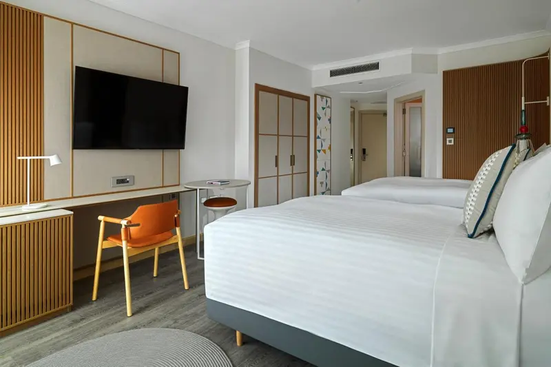 Une chambre lumineuse avec un lit double et un coin salon.
