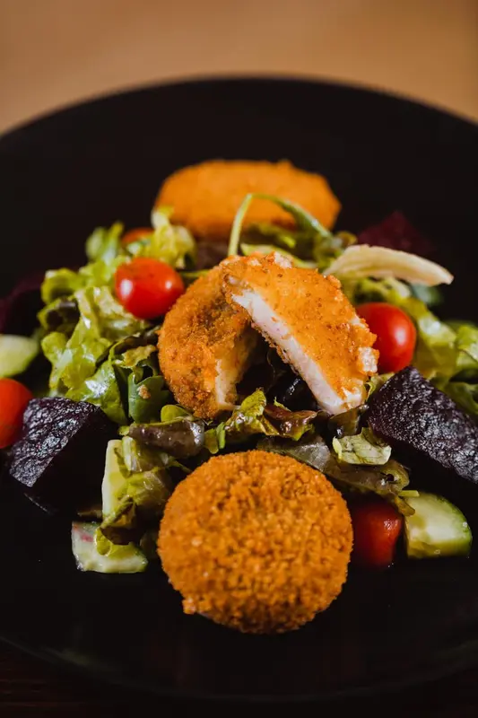 Salade composée avec des croquettes et des légumes frais.