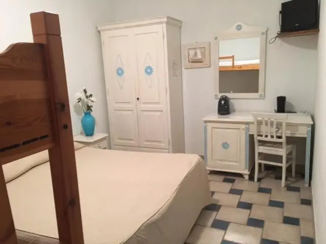 Une chambre lumineuse avec un lit, un bureau et une armoire.