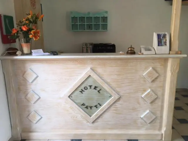 Un comptoir d'accueil en bois clair avec une décoration florale.
