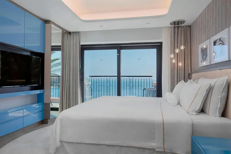 Une chambre lumineuse avec un grand lit et une vue sur la mer.
