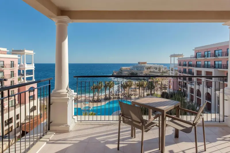 Terrasse avec mobilier d'extérieur donnant sur la mer et une piscine.