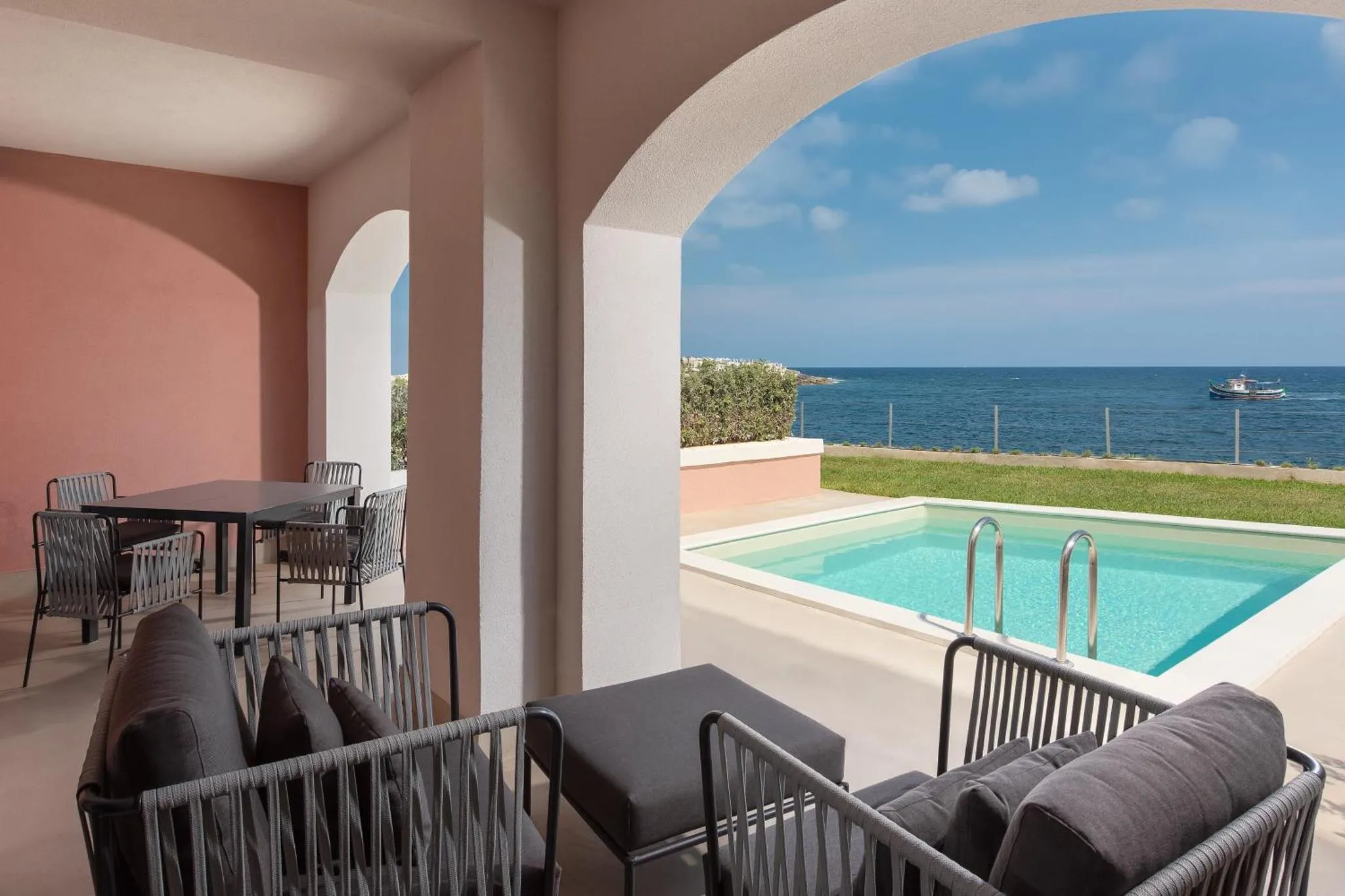 Terrasse ombragée avec salon et petite piscine donnant sur la mer.