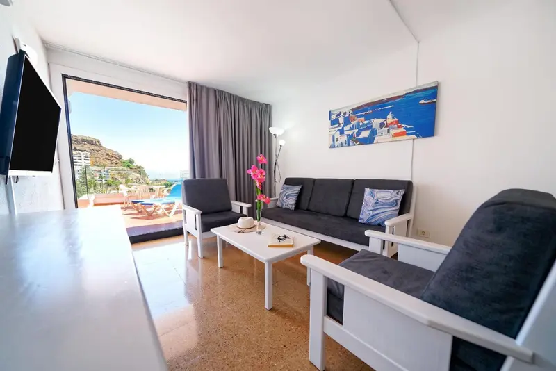Un salon lumineux avec canapés et vue sur la mer.