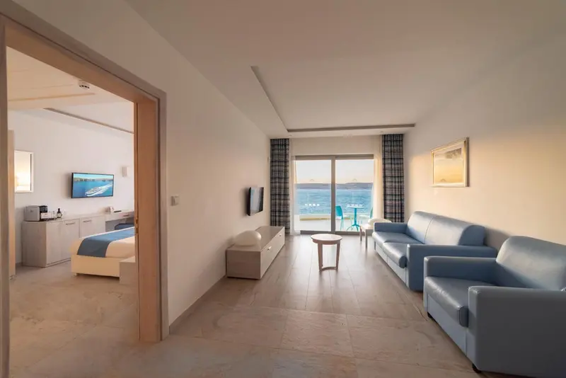 Espace de vie lumineux avec canapés bleus et vue sur la mer.