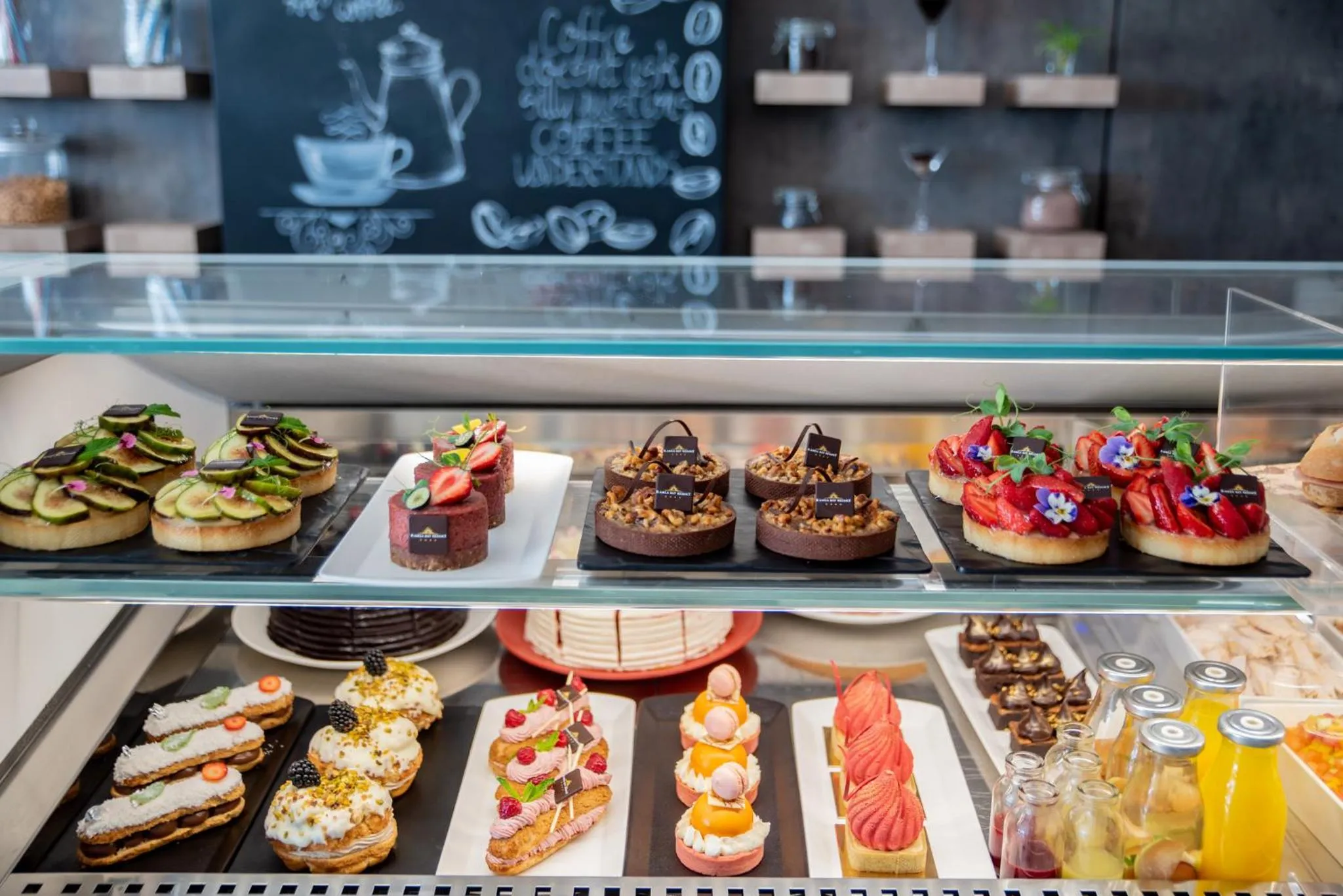 Présentation de pâtisseries et de gâteaux dans une vitrine réfrigérée.