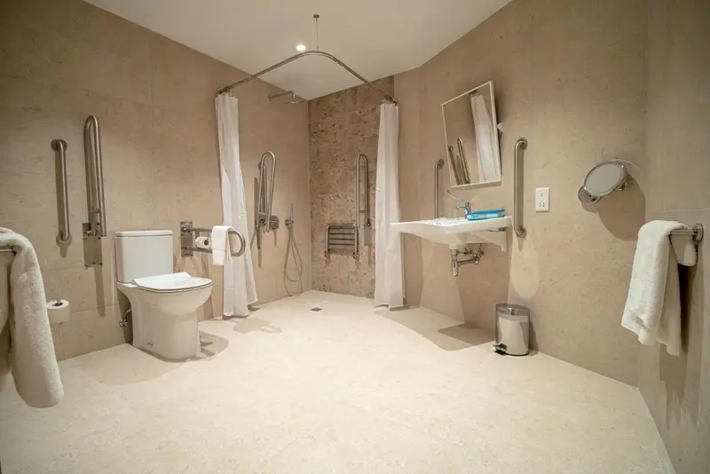 Une salle de bain spacieuse et accessible avec douche à l'italienne et toilettes.