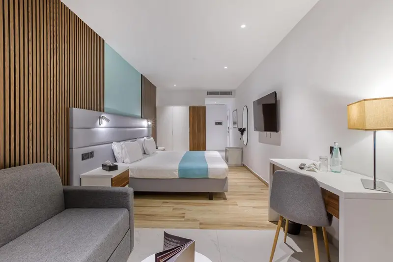 Une chambre lumineuse avec un grand lit et un espace détente.