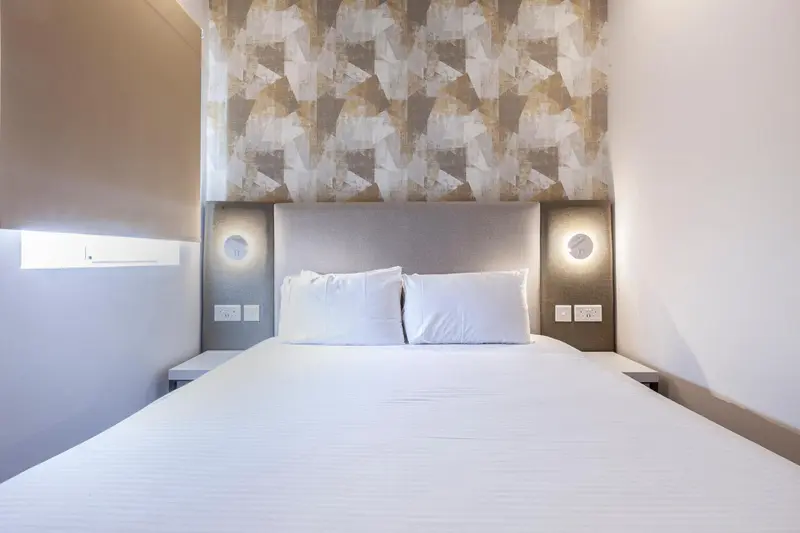 Lit double dans une chambre au décor sobre et moderne.