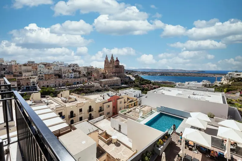 Vue aérienne sur une ville côtière et une piscine d'hôtel.