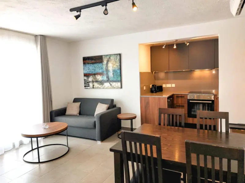 Espace de vie avec canapé, table basse et coin repas.