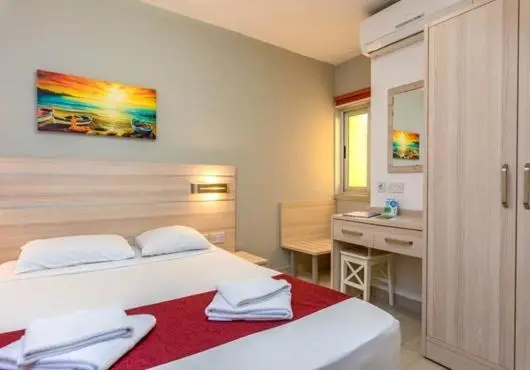 Une chambre lumineuse avec un lit double et un bureau.
