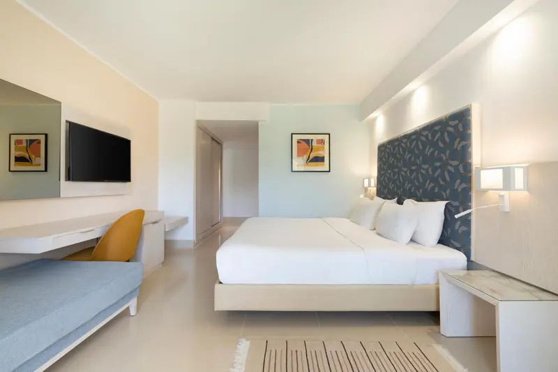 Une chambre lumineuse avec un grand lit et un canapé.