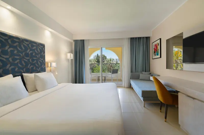 Une chambre lumineuse avec un grand lit et un espace détente.