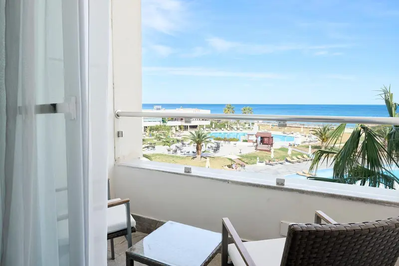 Vue sur la mer depuis un balcon avec mobilier d'extérieur.
