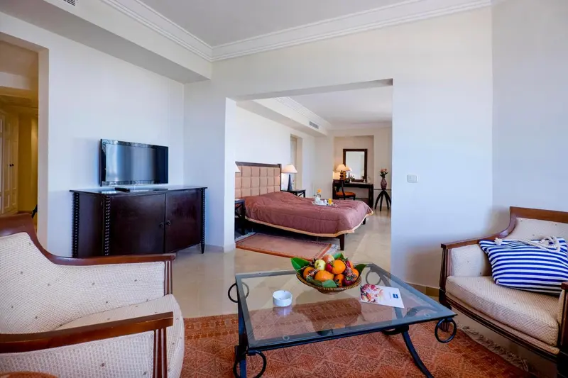 Une chambre lumineuse avec un coin salon et un lit décoré de fruits.