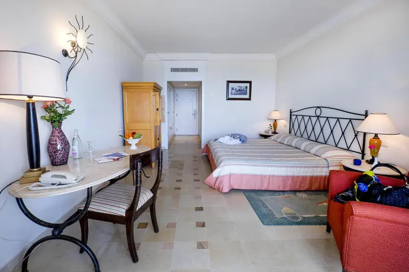 Une chambre lumineuse avec un lit et un coin bureau.