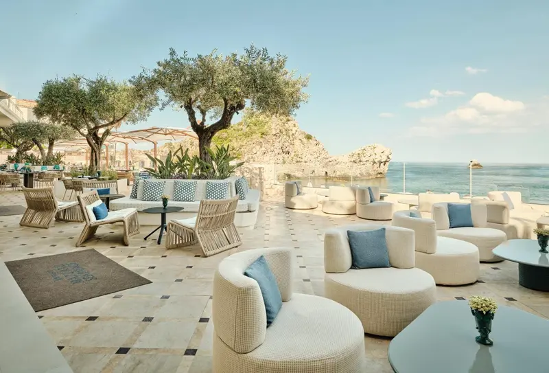 Espace de détente extérieur avec mobilier confortable et vue sur la mer.