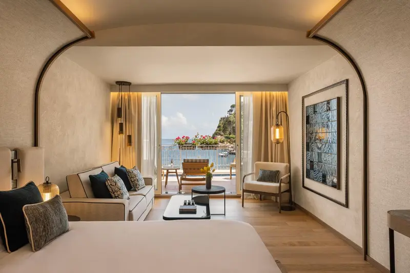 Espace de séjour lumineux avec canapé et vue sur la mer.