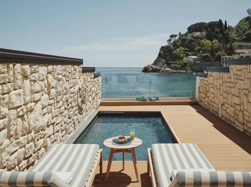 Terrasse avec piscine et vue sur la mer.