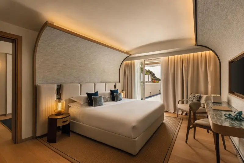 Une chambre lumineuse avec un grand lit et un accès à une terrasse.