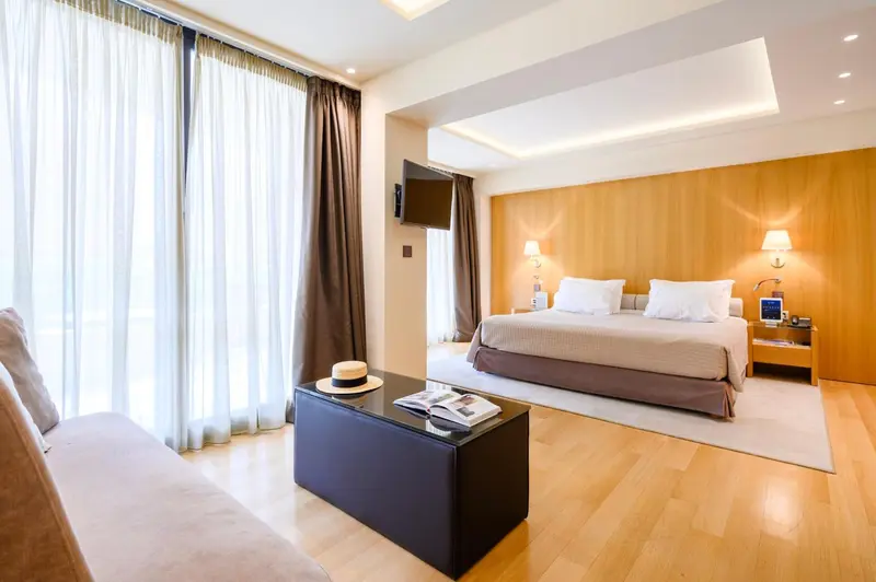 Une chambre lumineuse avec un grand lit et un coin salon.