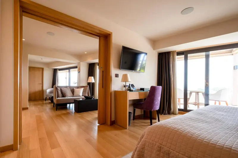 Une chambre lumineuse s'ouvre sur un espace de vie avec canapé et accès à une terrasse.