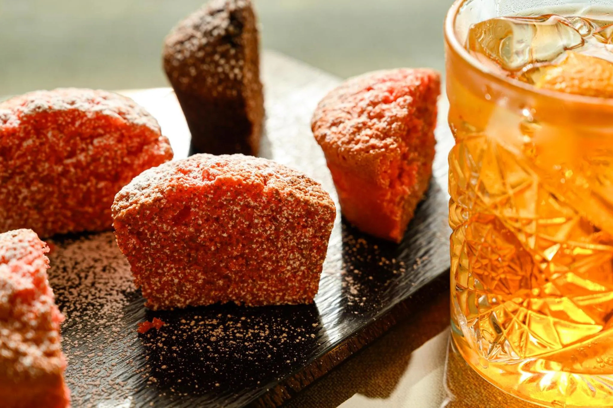 Des pâtisseries saupoudrées de sucre et une boisson rafraîchissante servie avec des glaçons.