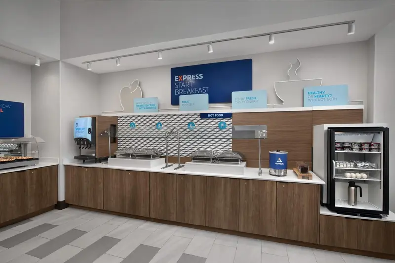 Un comptoir de buffet propose des plats variés dans une salle lumineuse.
