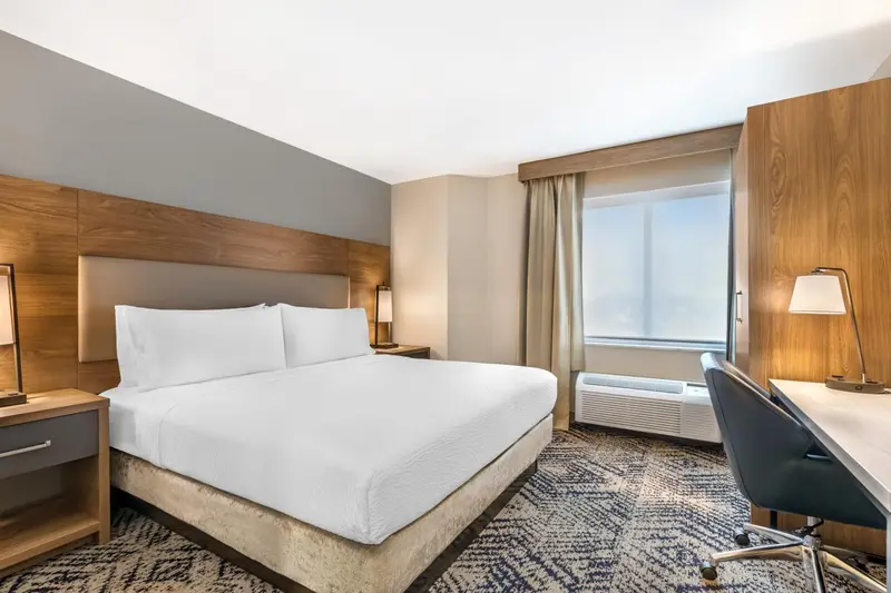 Une chambre d'hôtel lumineuse avec un grand lit et un bureau.