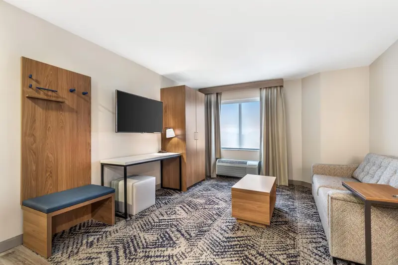 Une chambre d'hôtel moderne avec un coin salon et un bureau.