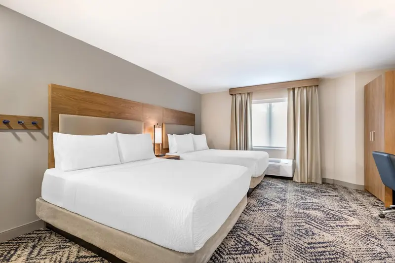 Une chambre d'hôtel avec deux lits simples et un bureau.