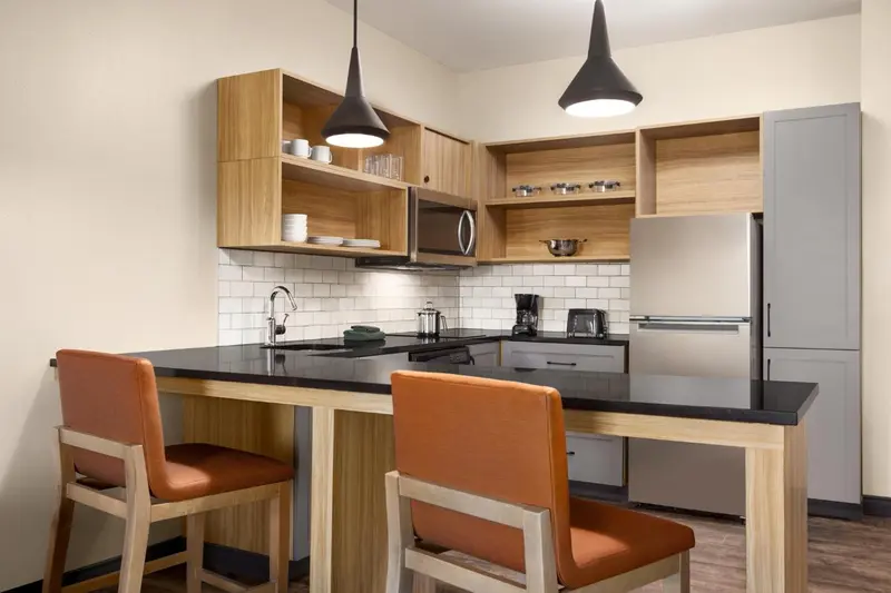 Une cuisine moderne avec un plan de travail et deux tabourets.