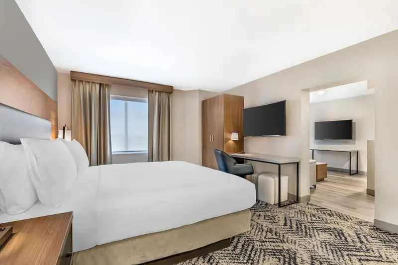 Une chambre d'hôtel lumineuse avec un grand lit et un espace bureau.