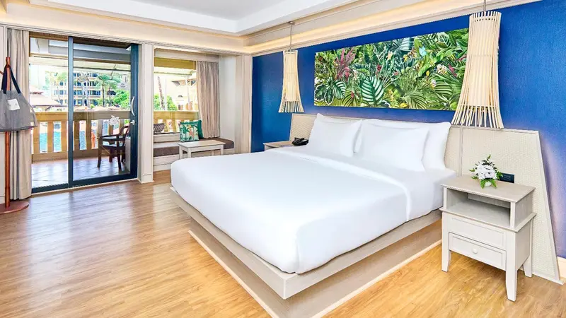 Une chambre lumineuse avec un grand lit et un accès à un balcon.