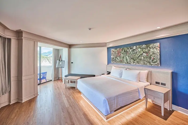Une chambre lumineuse avec un grand lit et un tableau décoratif.