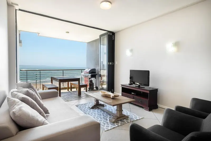 Un salon lumineux s'ouvre sur une terrasse avec vue sur la mer.