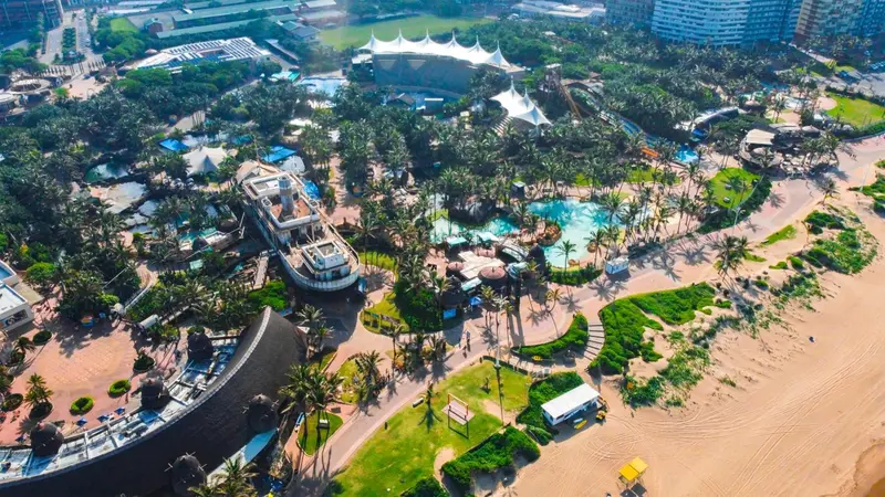 Vue aérienne d'un complexe hôtelier avec piscine et plage.