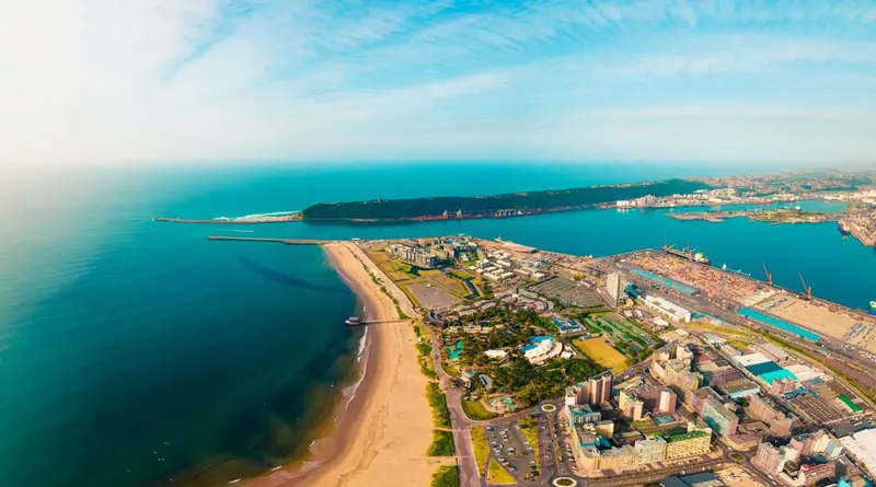 Vue aérienne d'une côte avec une plage de sable et une ville portuaire.
