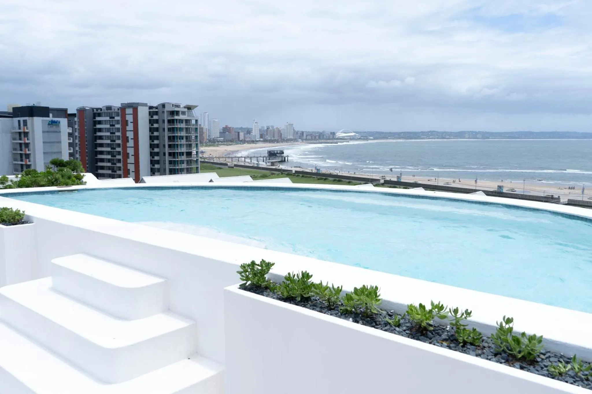 Une piscine à débordement offre une vue sur la mer et la côte.