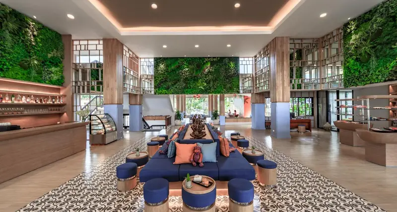 Un espace de détente intérieur avec des canapés bleus et des fauteuils colorés.