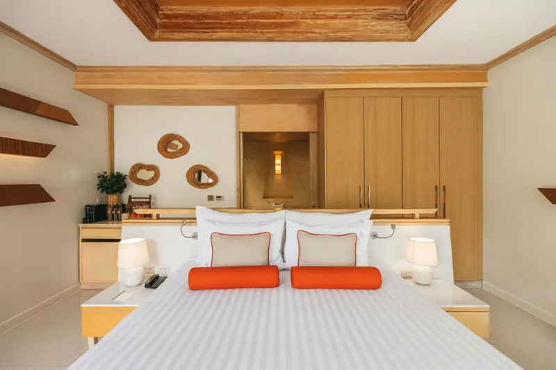 Une chambre lumineuse avec un grand lit et une décoration sobre.