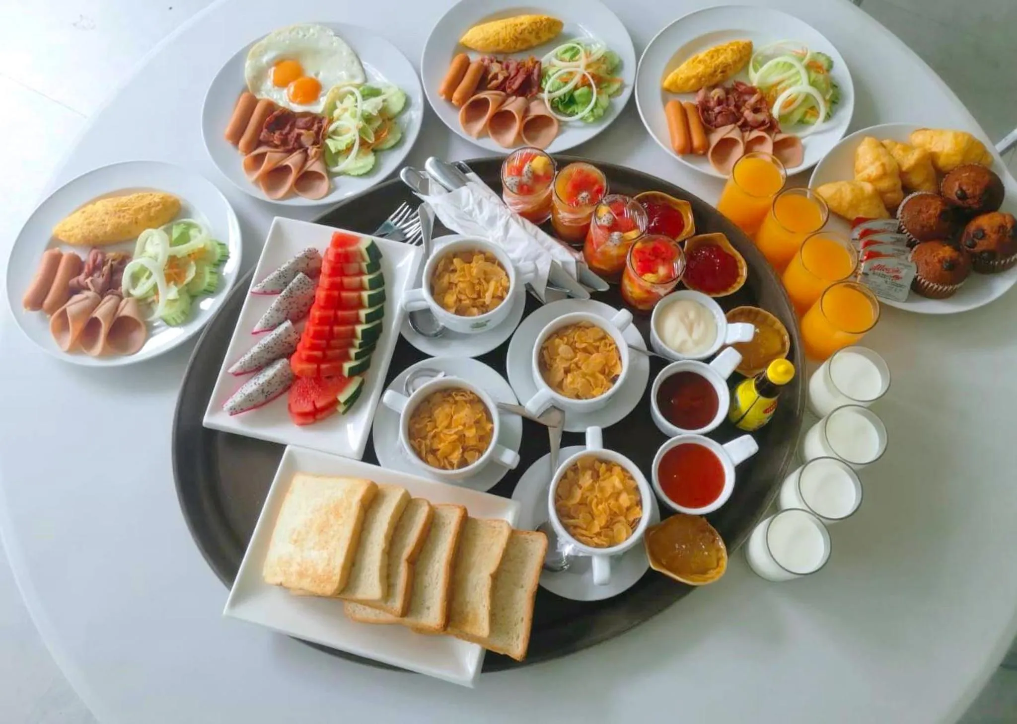 Un plateau garni de divers plats et boissons pour le petit-déjeuner.