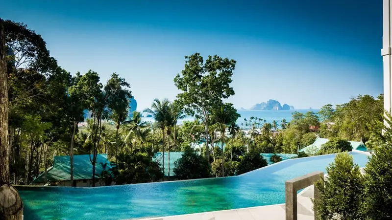 Une piscine à débordement offre une vue sur la mer et les îles verdoyantes.
