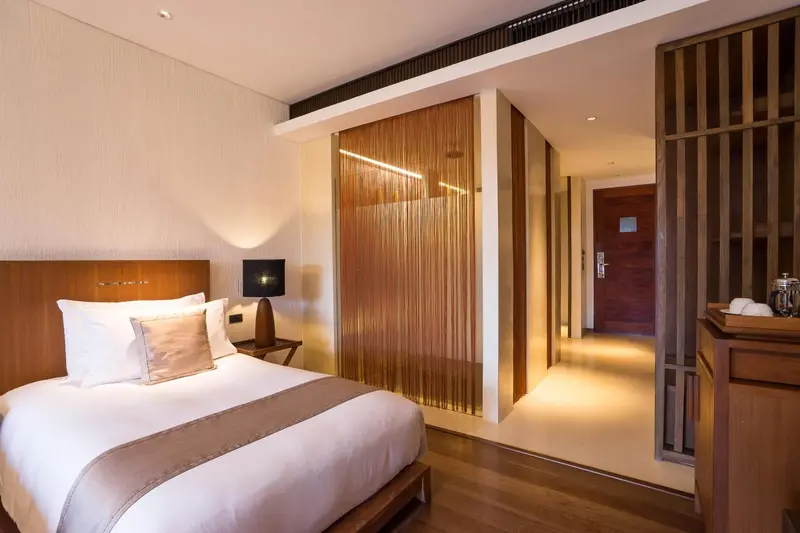 Une chambre lumineuse avec un grand lit et un décor en bois.