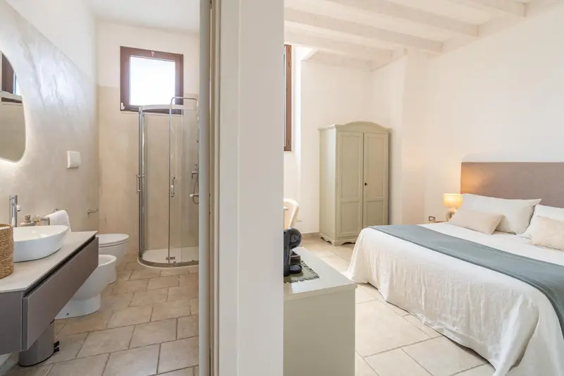 Une chambre lumineuse avec salle de bain attenante et espace rangement.